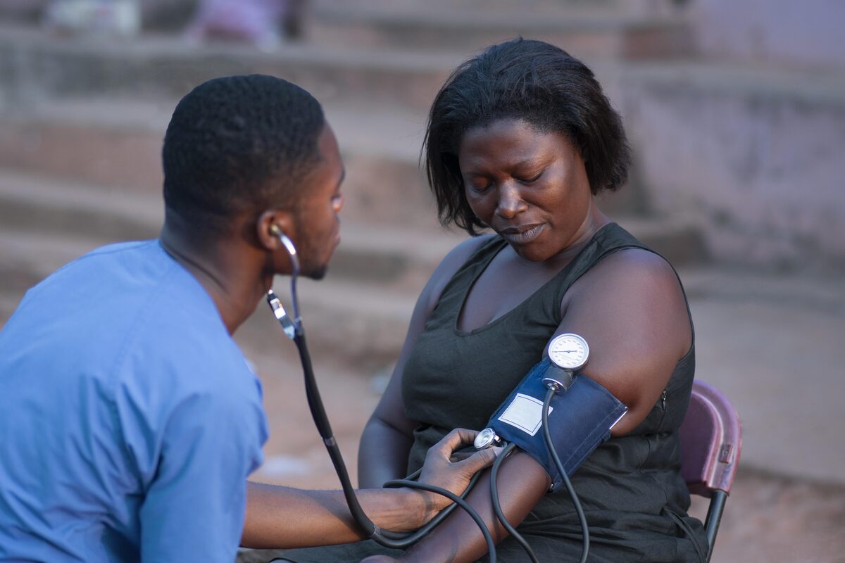 A health worker checking an African woman’s blood pressure at a community clinic